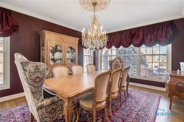 dining space featuring ornamental molding, hardwood / wood-style floors, and a chandelier