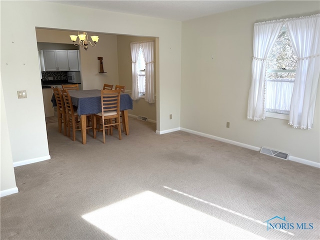 carpeted dining area with a wealth of natural light and a chandelier