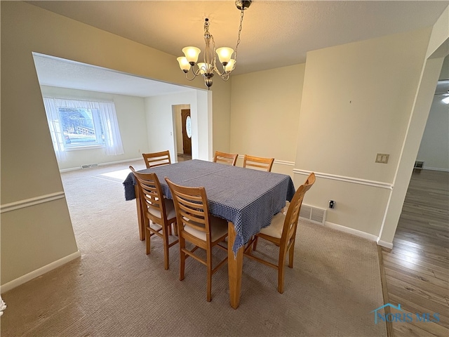 carpeted dining area featuring a chandelier