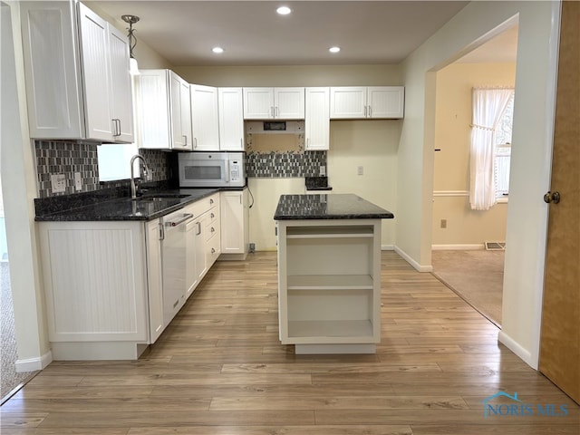 kitchen featuring hanging light fixtures, white cabinetry, a center island, and dishwasher