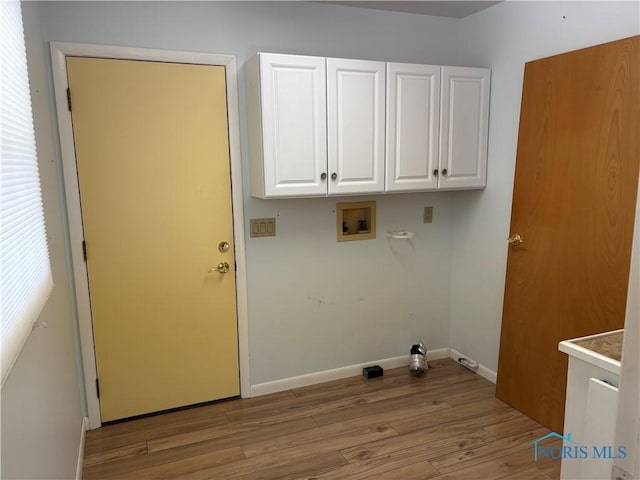 laundry area featuring cabinets, washer hookup, and light hardwood / wood-style floors