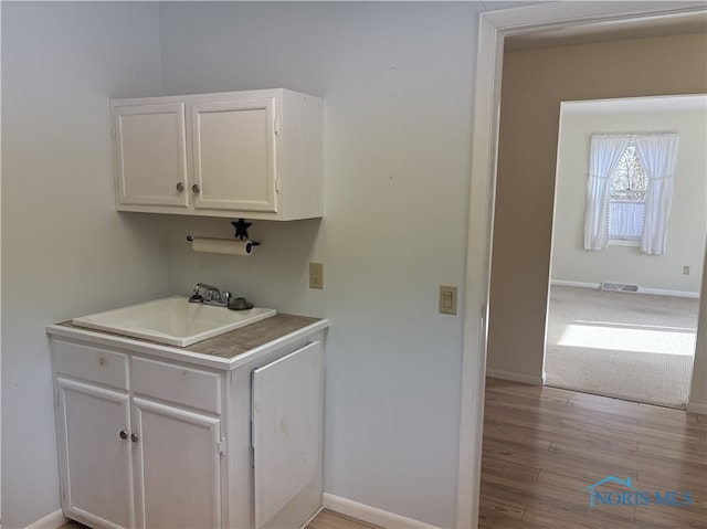 washroom with sink and light hardwood / wood-style floors