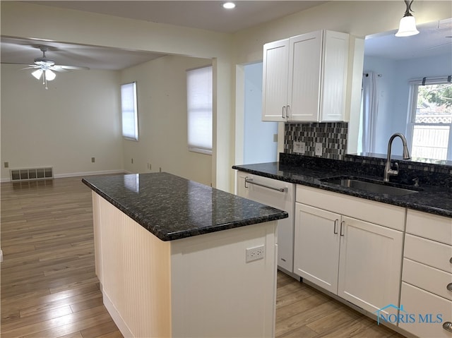 kitchen featuring sink, dark stone countertops, and white cabinets