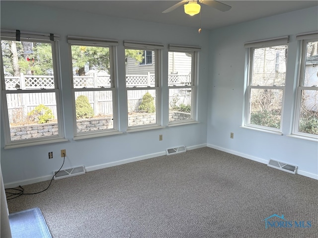 carpeted spare room featuring ceiling fan