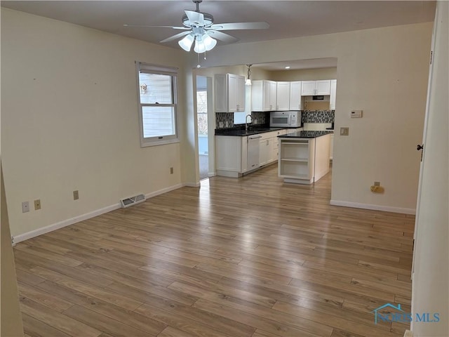 kitchen with wood-type flooring, sink, white cabinets, ceiling fan, and white appliances