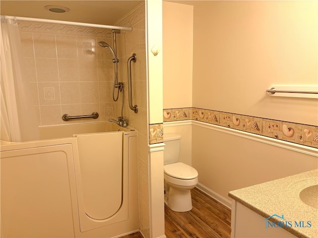 full bathroom featuring hardwood / wood-style flooring, vanity, toilet, and tiled shower / bath combo