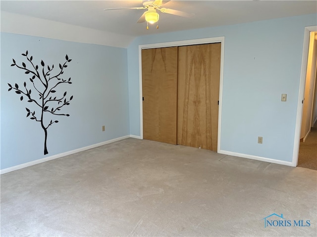 unfurnished bedroom featuring carpet floors, ceiling fan, and a closet