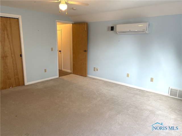 carpeted spare room with an AC wall unit and ceiling fan