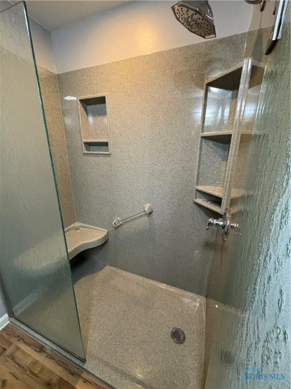 bathroom with a shower and wood-type flooring