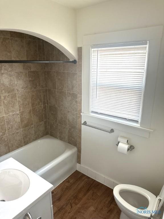 full bathroom featuring vanity, hardwood / wood-style flooring, tub / shower combination, and toilet