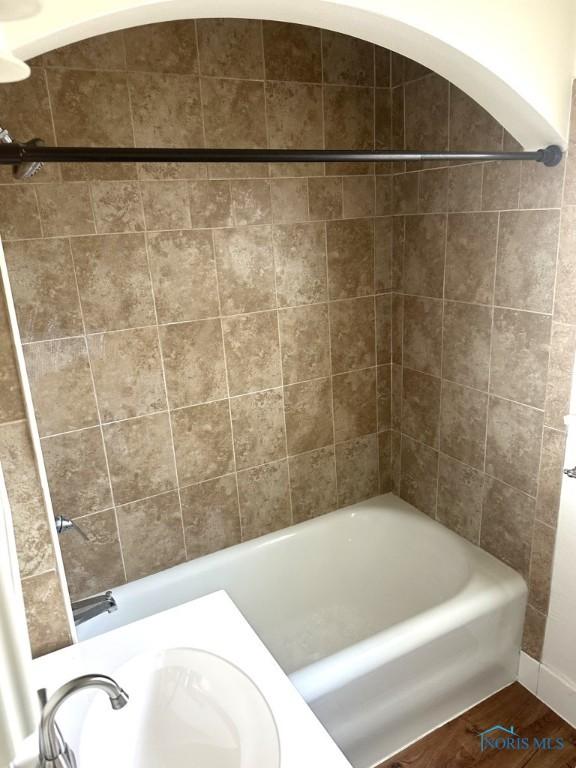 bathroom featuring tiled shower / bath, wood-type flooring, and sink