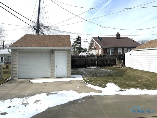 snow covered garage with a yard