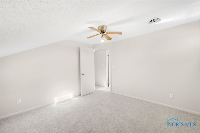 additional living space with vaulted ceiling, carpet, ceiling fan, and a textured ceiling