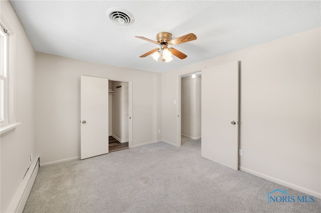 unfurnished bedroom featuring a baseboard radiator, light carpet, ceiling fan, and a textured ceiling