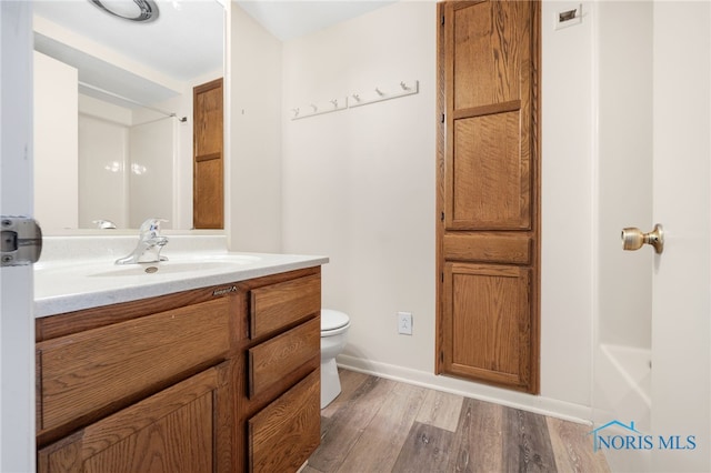 bathroom featuring vanity, wood-type flooring, and toilet