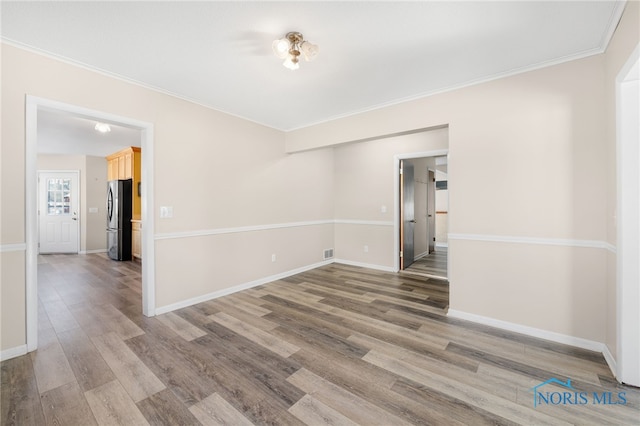 unfurnished room featuring hardwood / wood-style flooring and crown molding