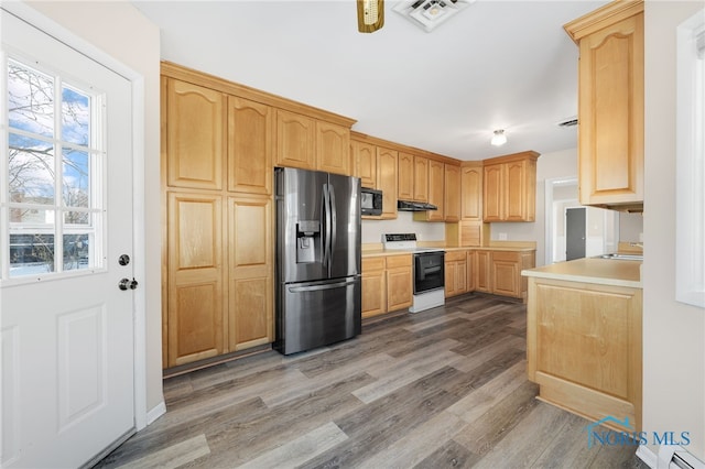 kitchen with sink, stainless steel refrigerator with ice dispenser, range with electric stovetop, wood-type flooring, and light brown cabinetry