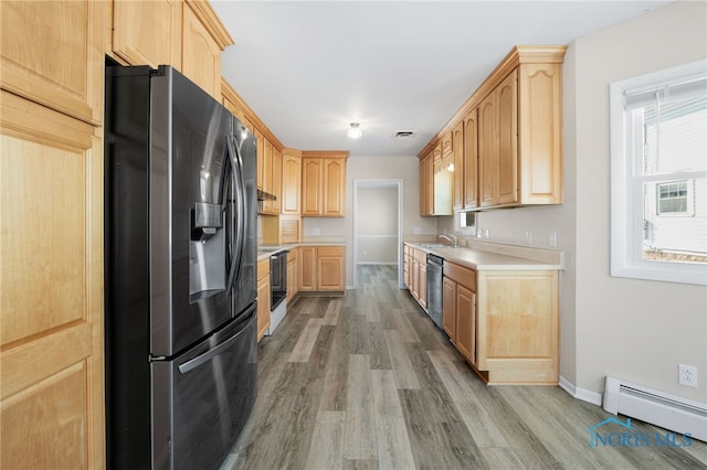 kitchen featuring sink, a baseboard heating unit, stainless steel appliances, light hardwood / wood-style floors, and light brown cabinetry