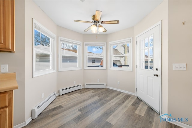 interior space featuring light wood-type flooring, ceiling fan, and baseboard heating