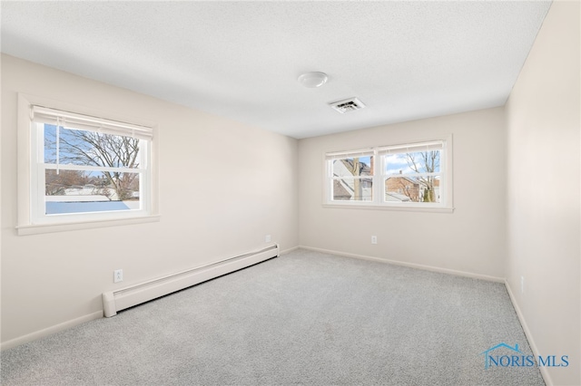 spare room featuring a baseboard radiator, light colored carpet, and a wealth of natural light