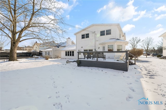 snow covered house featuring a deck