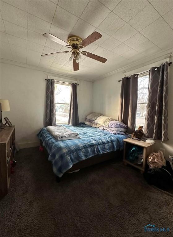 bedroom featuring multiple windows, carpet floors, and ceiling fan