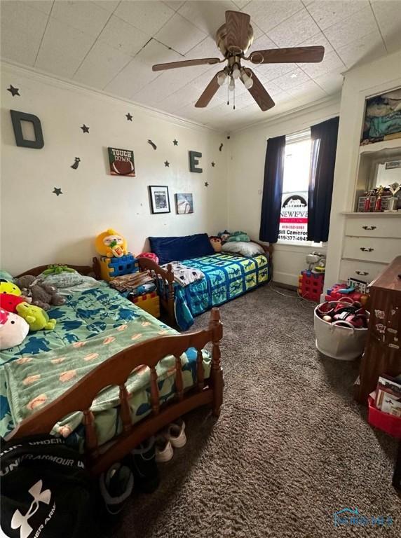 bedroom with crown molding, ceiling fan, and carpet