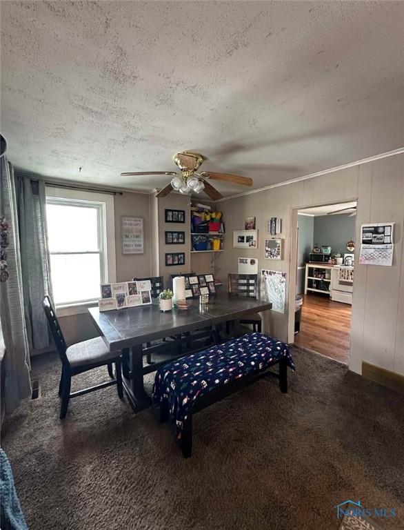 dining space with ceiling fan, a textured ceiling, and carpet flooring