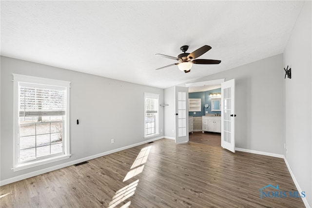 unfurnished living room with dark hardwood / wood-style flooring, plenty of natural light, and vaulted ceiling