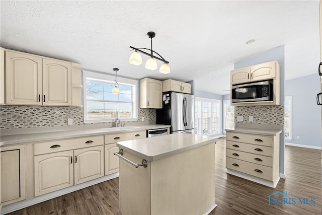 kitchen featuring sink, backsplash, hanging light fixtures, a center island, and stainless steel appliances