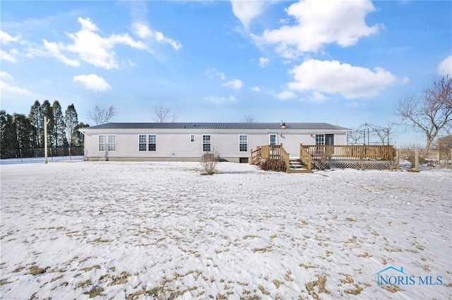 snow covered house with a wooden deck