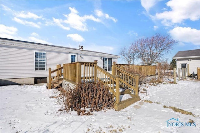 snow covered house with a deck