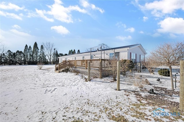 snow covered rear of property with a deck