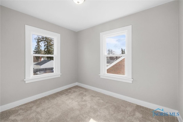 carpeted spare room featuring a healthy amount of sunlight