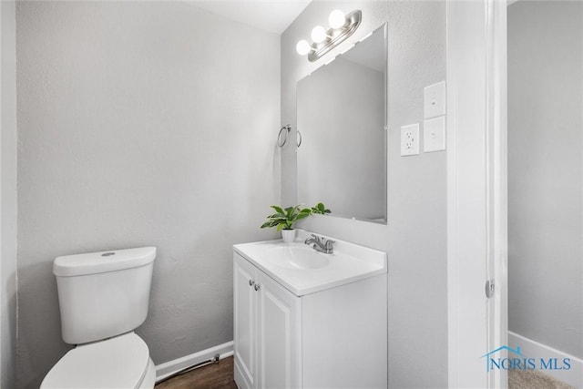 bathroom featuring vanity, toilet, and hardwood / wood-style floors