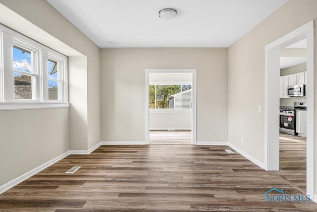 empty room with dark hardwood / wood-style flooring