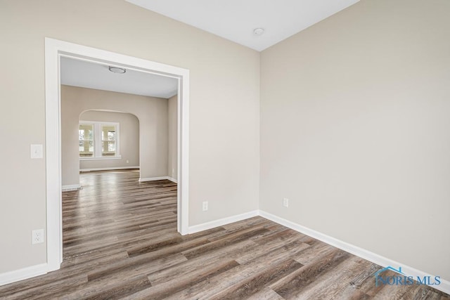 empty room with dark hardwood / wood-style flooring