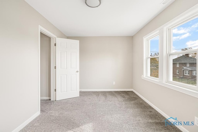 spare room featuring light colored carpet