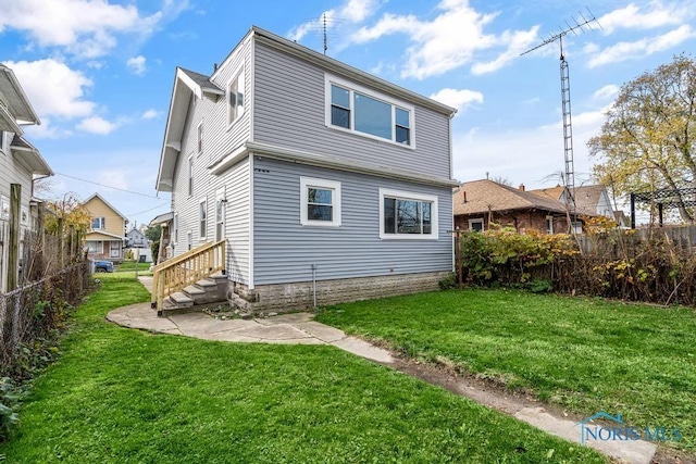 rear view of property with a lawn