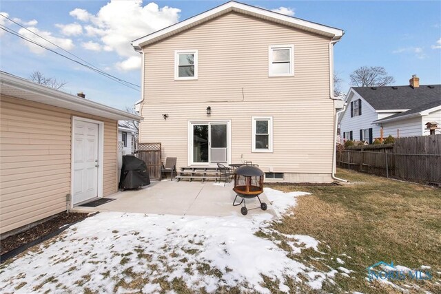 snow covered rear of property with a fire pit, a yard, and a patio area