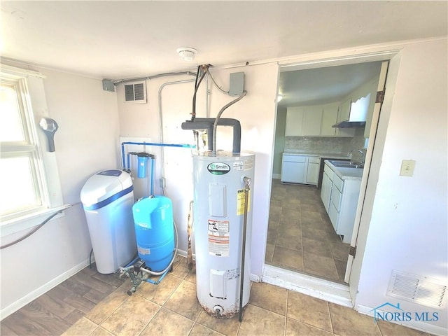 utility room featuring washer / dryer, sink, and water heater