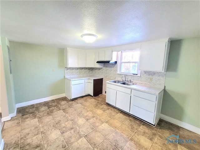 kitchen with white cabinetry, sink, and a textured ceiling