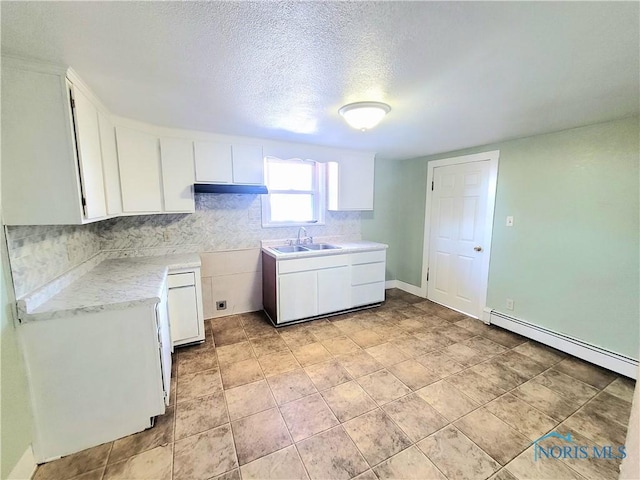 kitchen with white cabinetry, a baseboard radiator, sink, and a textured ceiling