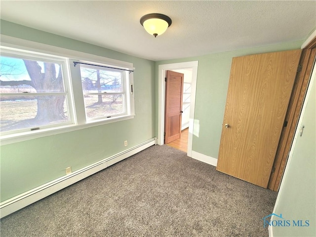 unfurnished bedroom featuring a baseboard radiator, carpet floors, and a closet