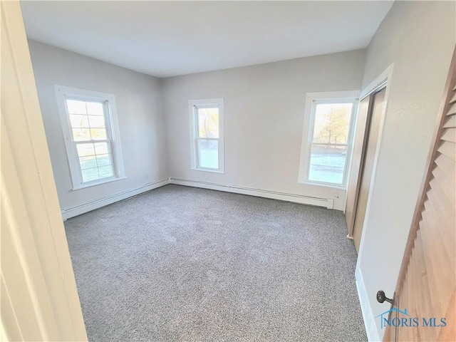 carpeted empty room featuring a baseboard radiator