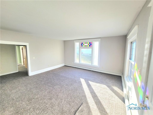 unfurnished room featuring carpet flooring and a baseboard heating unit