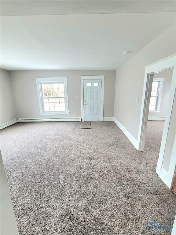 unfurnished living room with carpet floors and a wealth of natural light