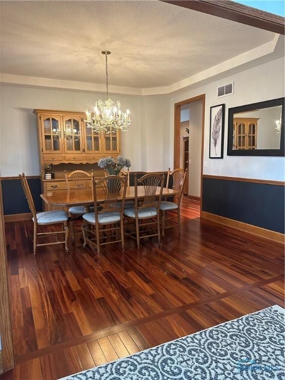 dining area featuring a notable chandelier and dark hardwood / wood-style floors