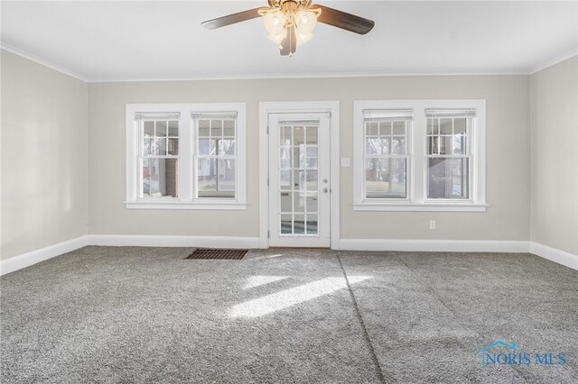 carpeted spare room featuring ornamental molding and ceiling fan