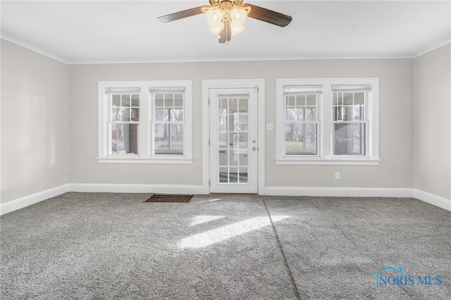 empty room featuring crown molding, ceiling fan, and carpet flooring